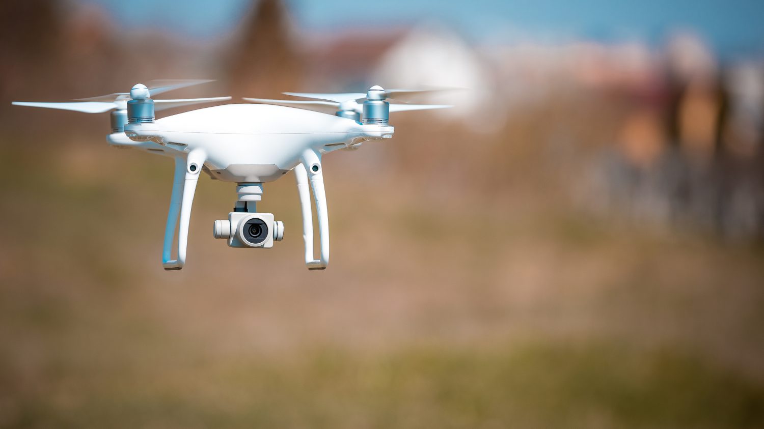 Close up on white drone camera. Drone quadcopter in flight